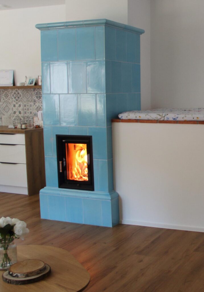 Těžká kachlová kamna s topeništěm Hoxter a prostorným vyhřívaným ležením. Hlavní těleso kamen je vystavěno z keramických kachlů v modré glazuře. V jednoduchosti je krása, nemyslíte? Foto zdroj: Jihočeské kamnářství